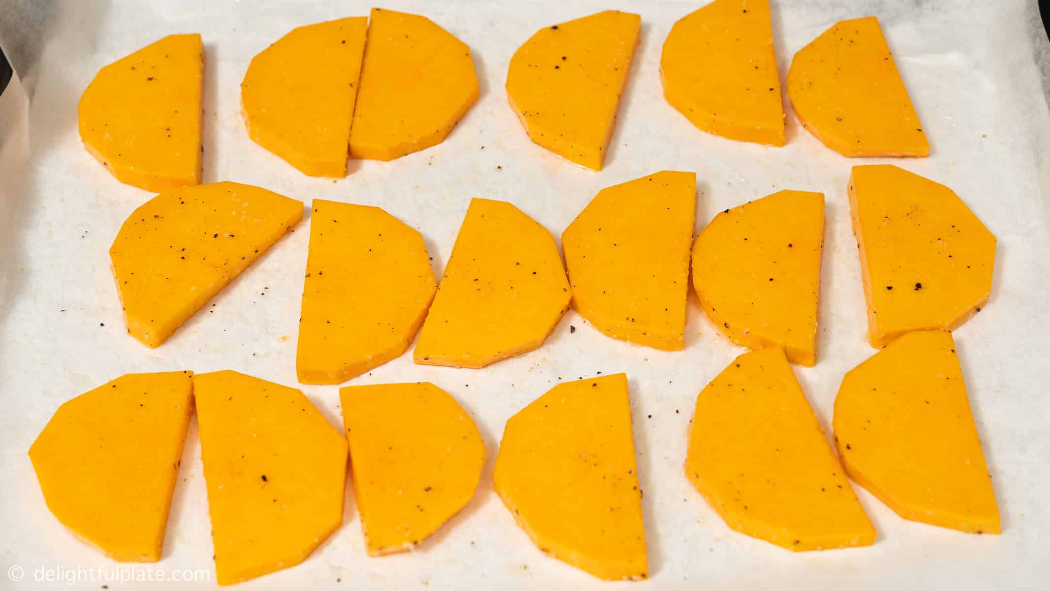 a baking sheet with butternut squash slices