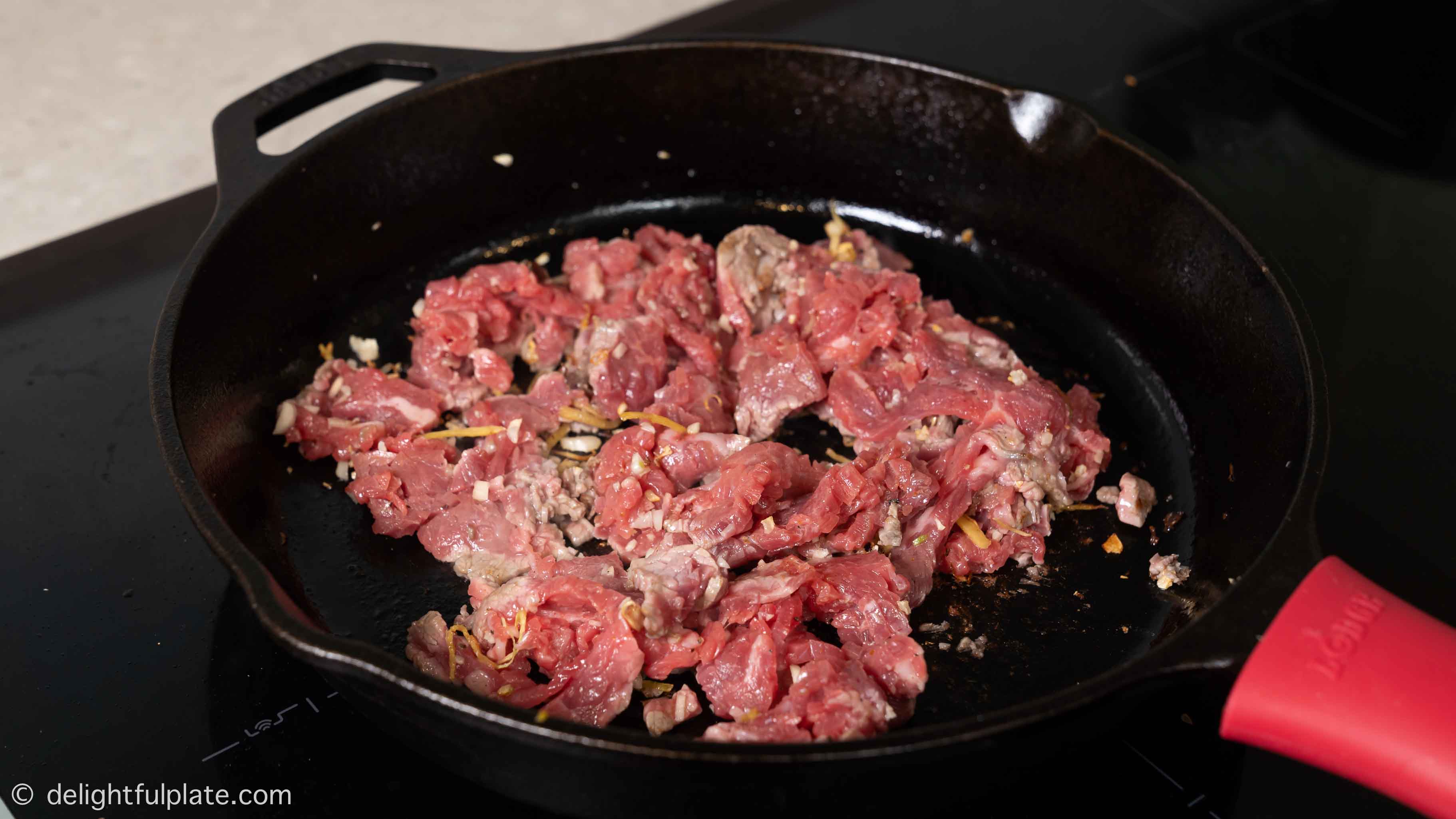 beef slices being seared in the skillet
