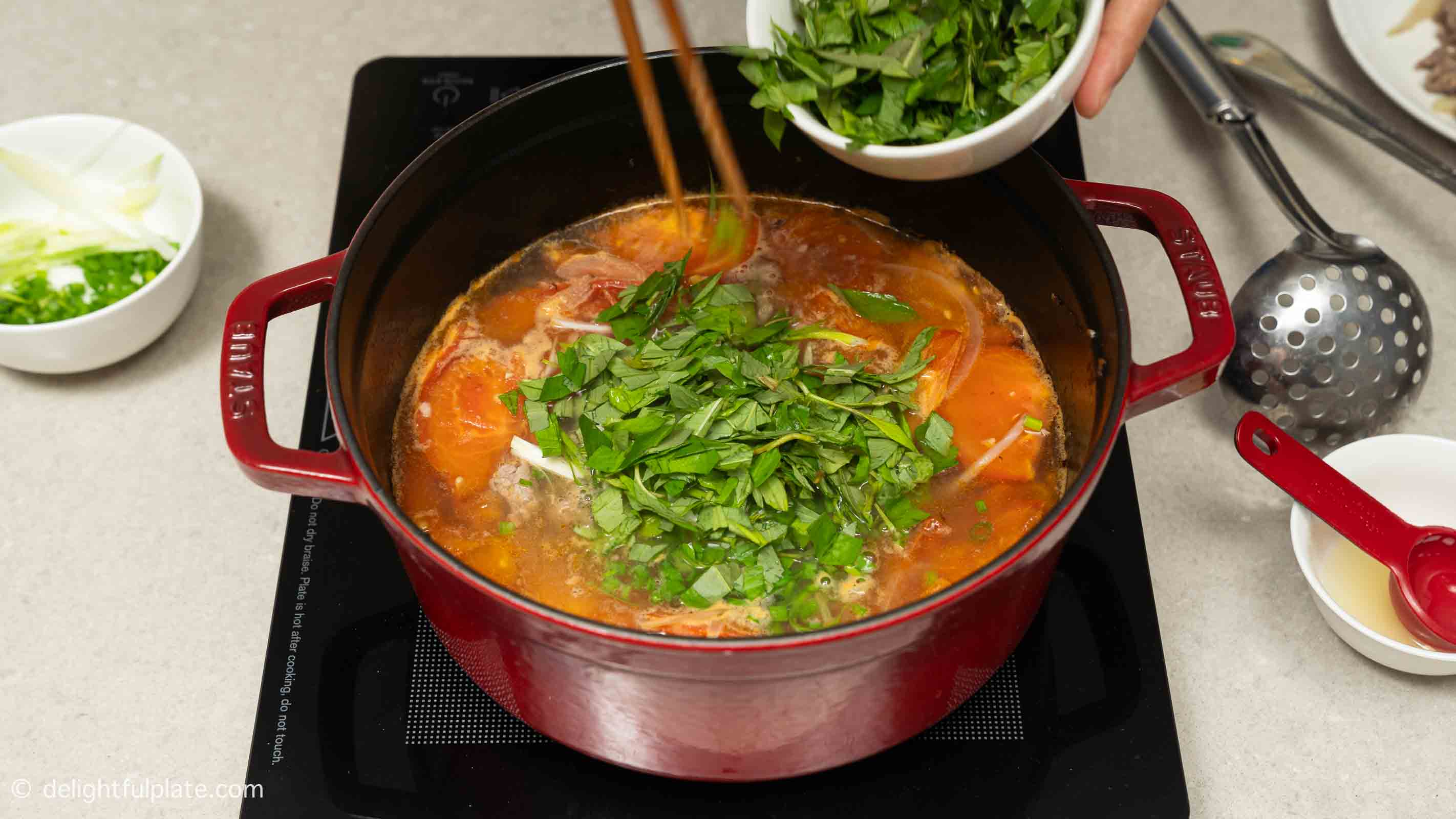 Adding Vietnamese coriander to the soup.