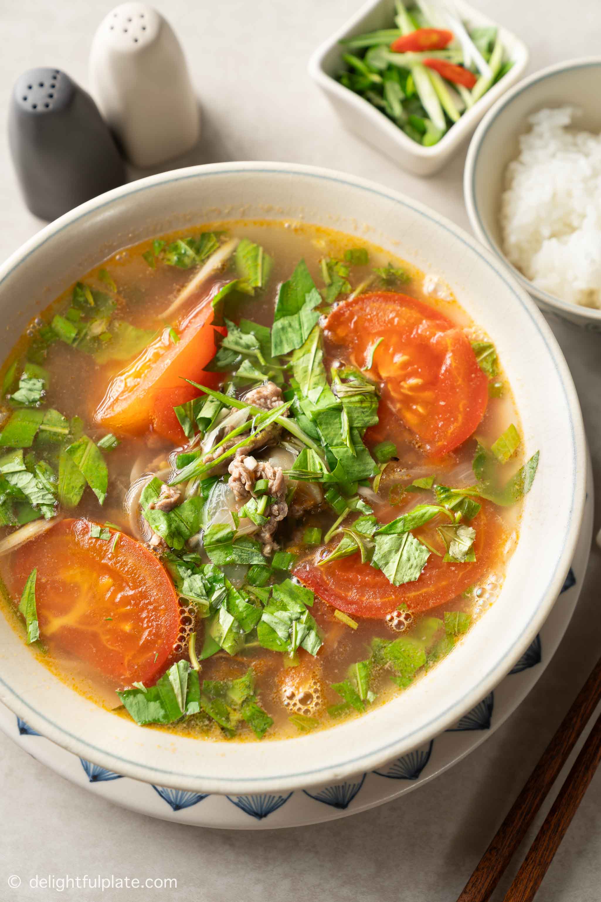 a bowl of Hanoi Tomato Beef Soup with Vietnamese Coriander (Canh Bo Rau Ram).
