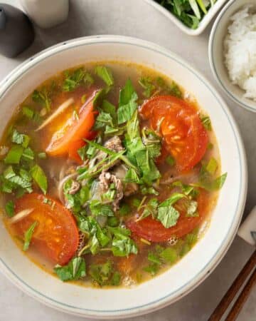 a bowl of Vietnamese tomato beef soup with coriander.