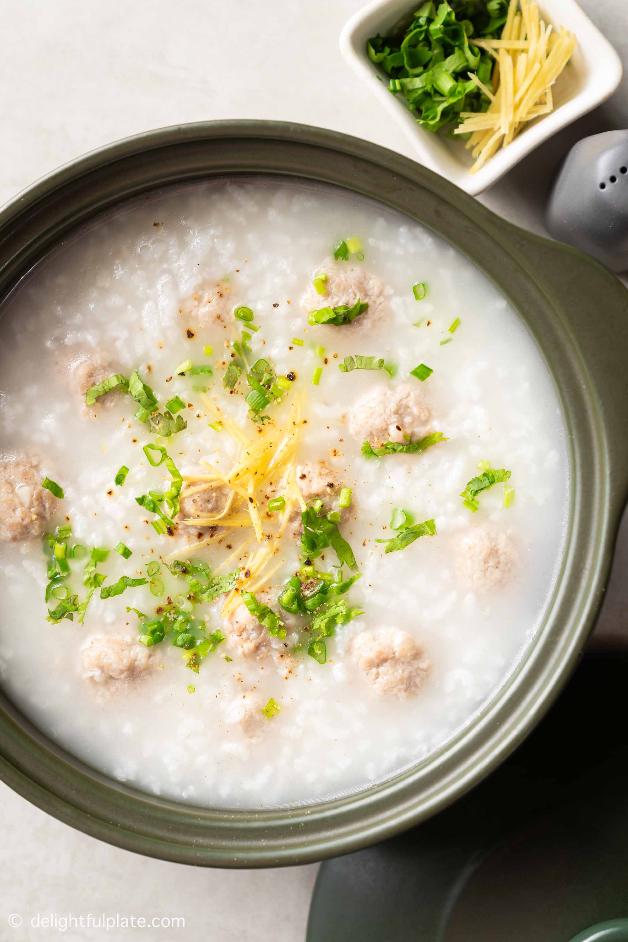 a pot of rice porridge with pork meatballs.