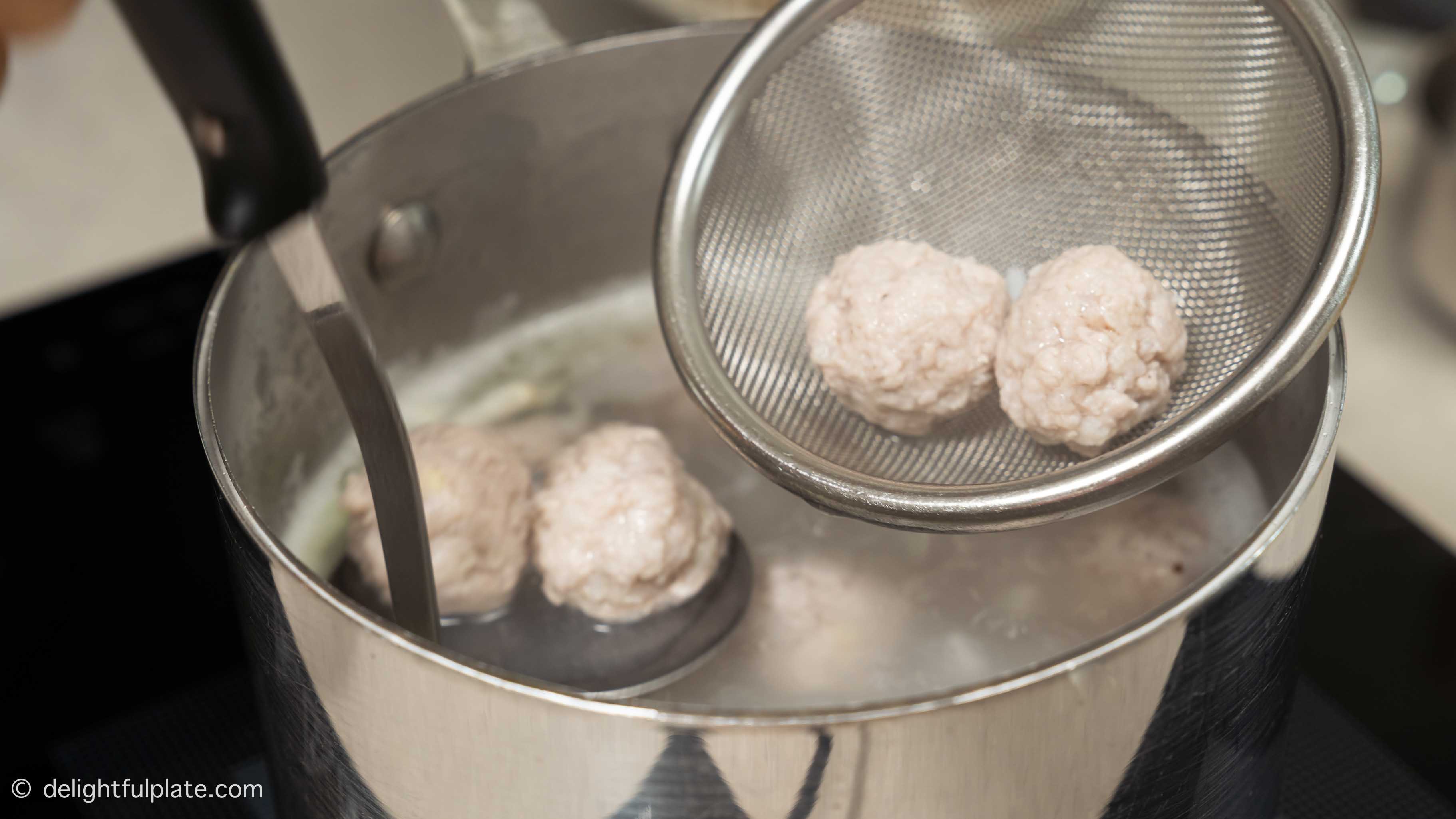 taking meatballs out of the congee pot.
