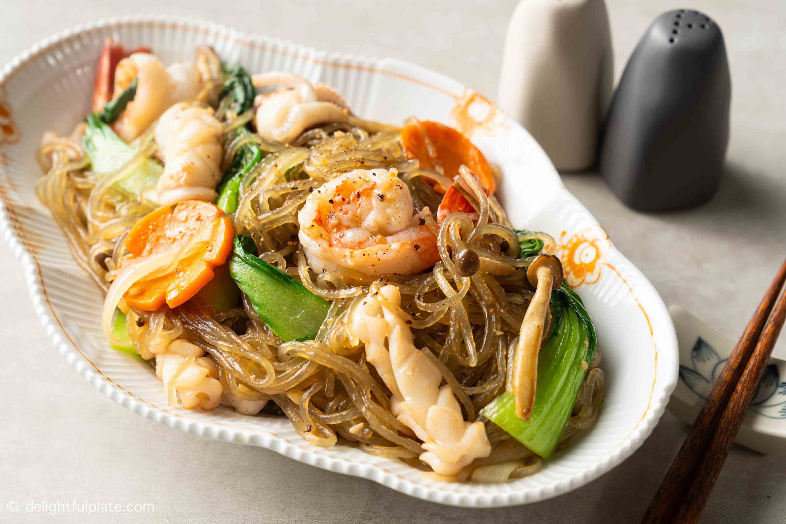 a plate of seafood and glass noodles stir-fry.