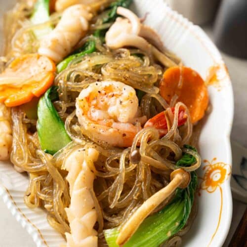 a plate of stir-fried glass noodles with seafood.