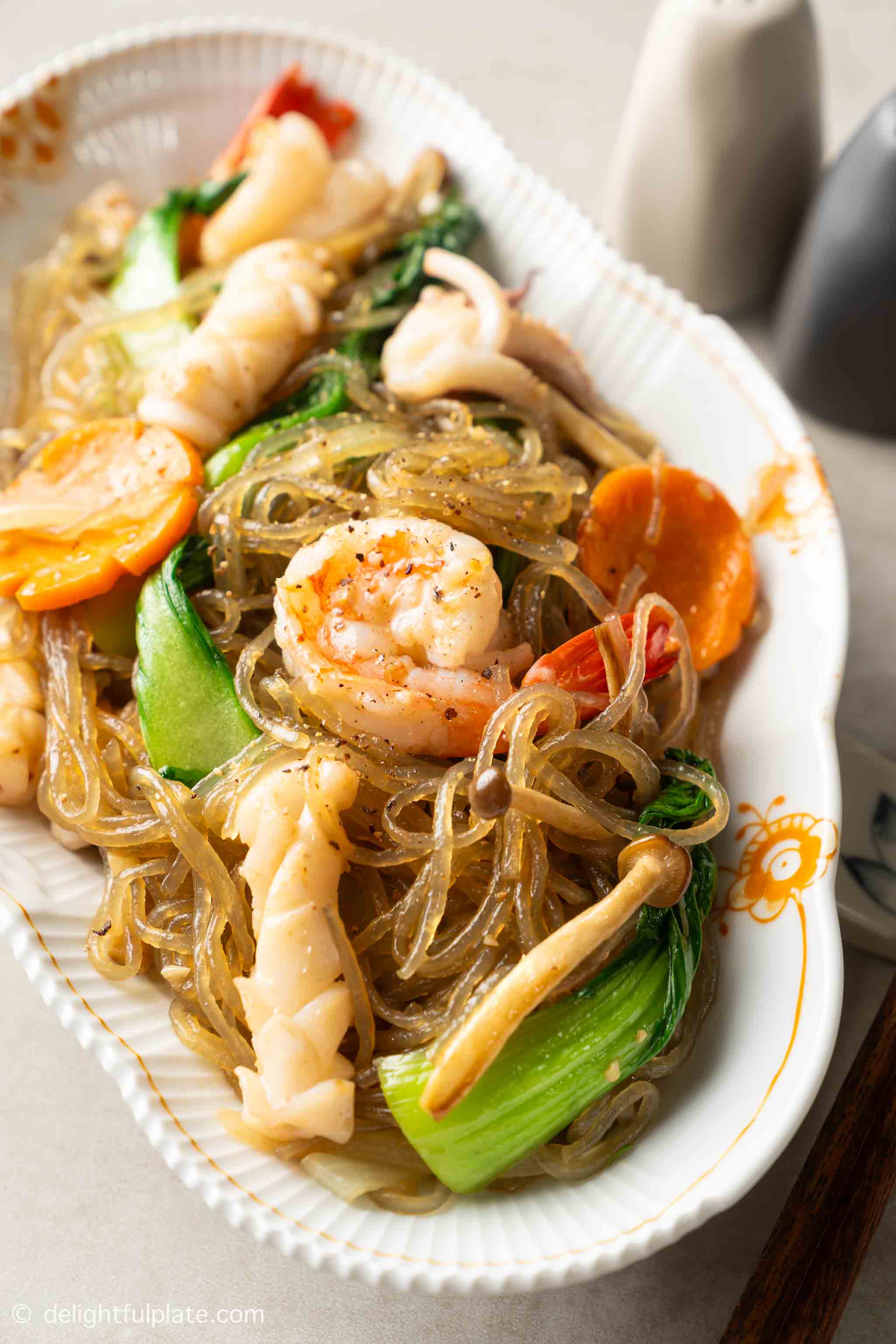 a plate of stir-fried glass noodles with seafood.