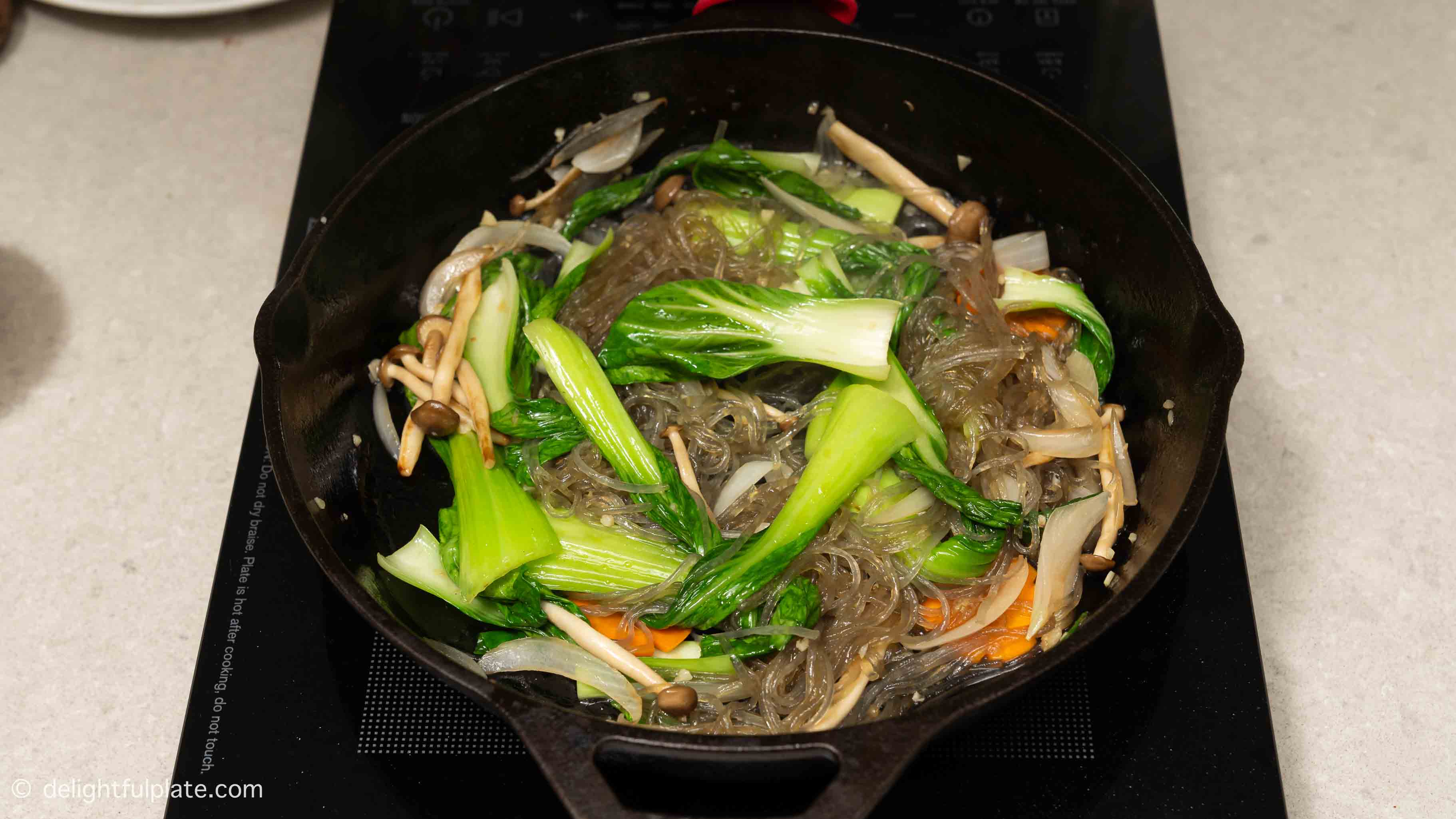 Stir-fry glass noodles with the vegetables in the skillet.