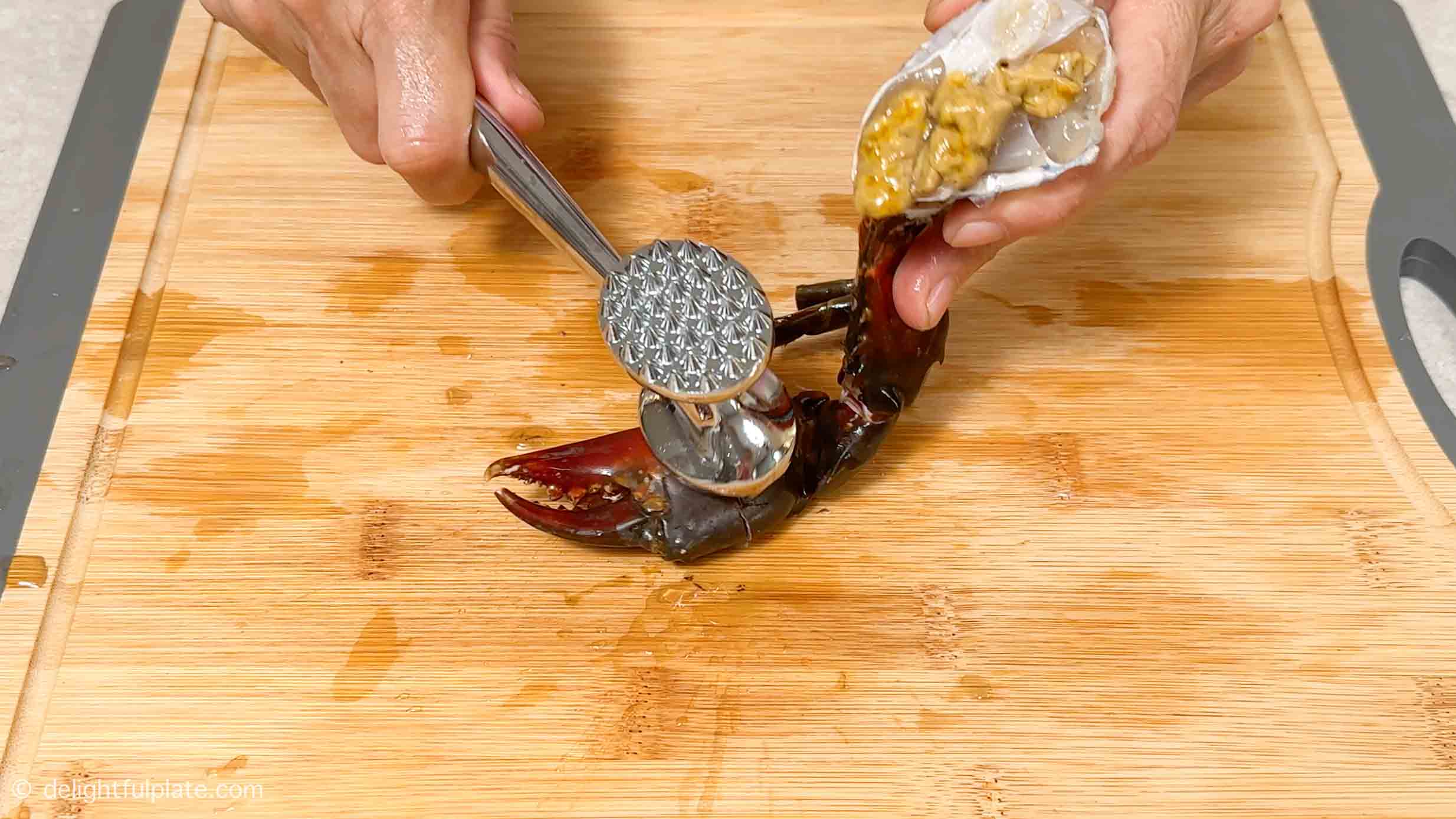 cracking a crab claw with a mallet.