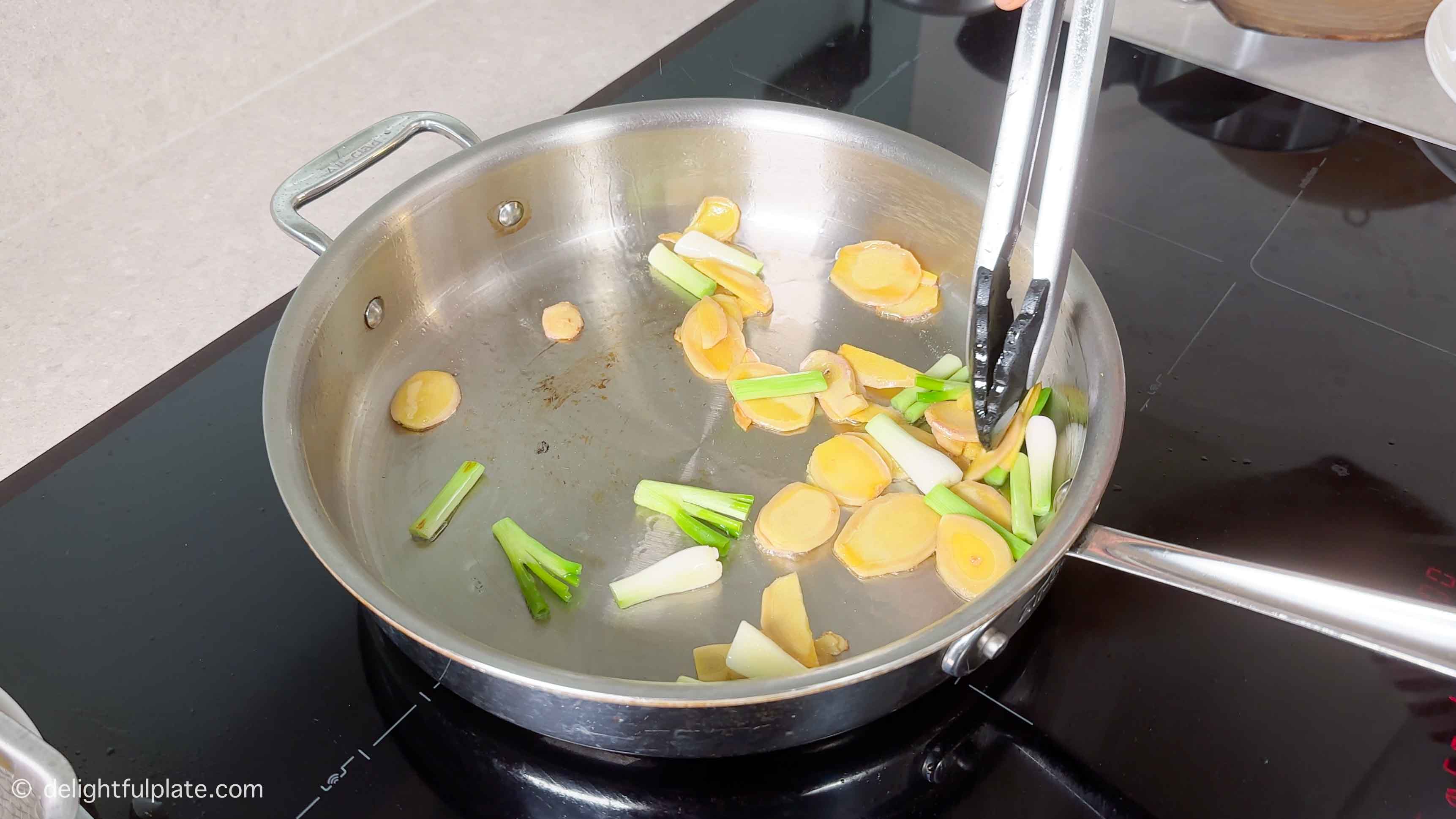 sautéing ginger and scallion in a stainless steel skillet.
