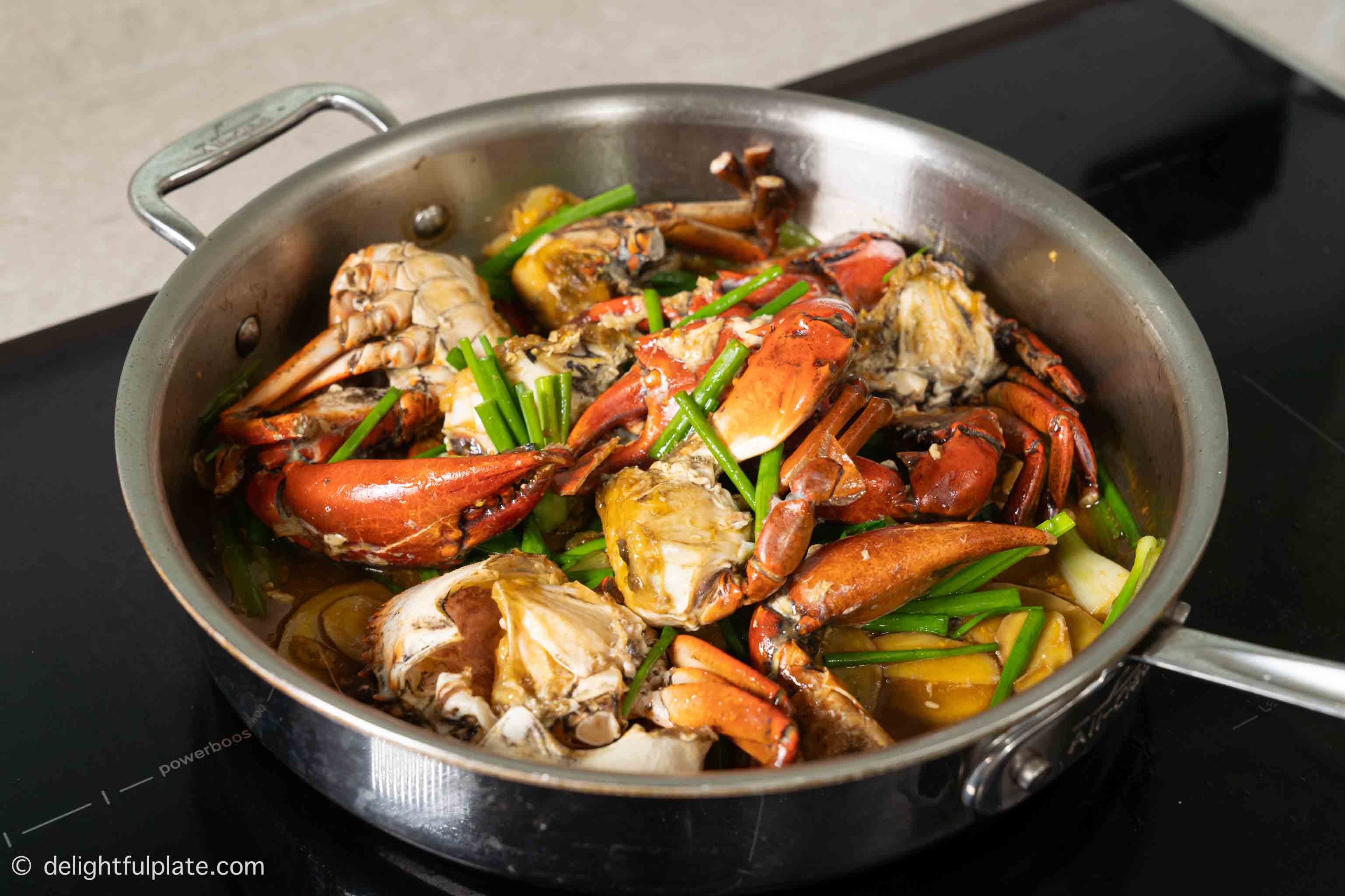 a skillet of freshly-cooked stir-fried crab with ginger and scallion.