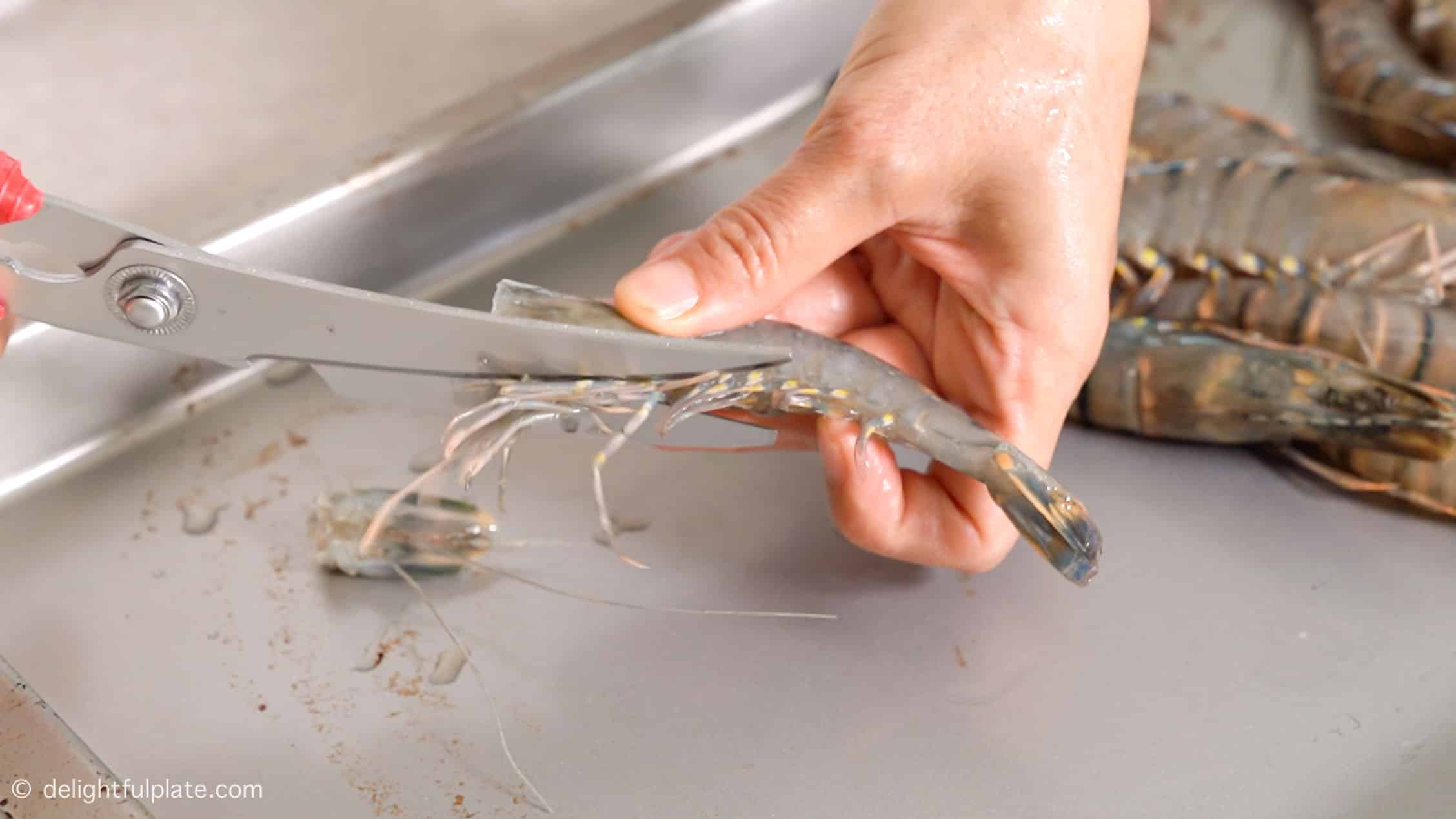 removing the shrimp legs with kitchen shears.