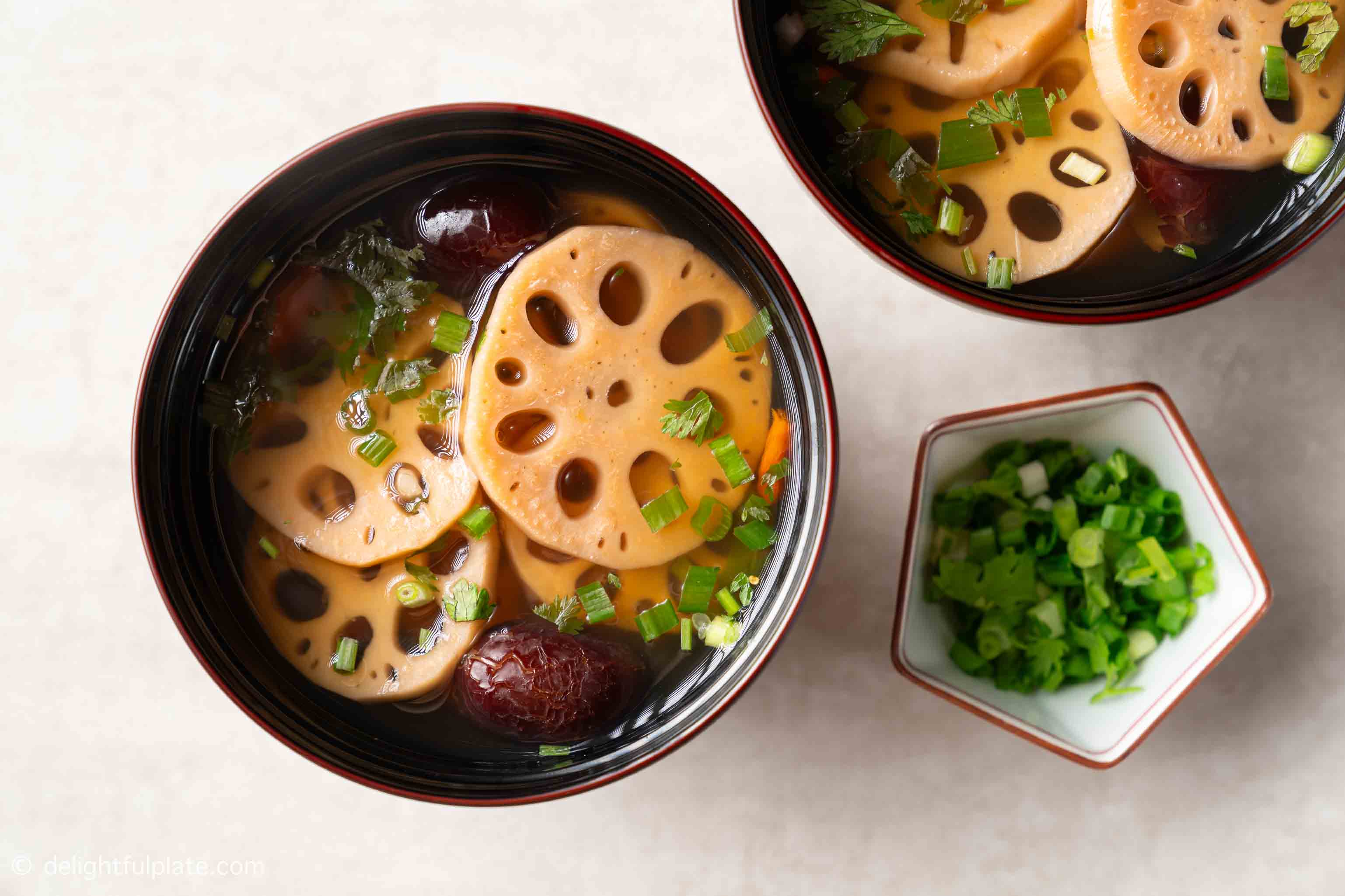 a bowl of lotus root soup with goji berries and red dates.