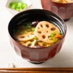 a bowl of vegan lotus root soup served in a lacquer bowl.