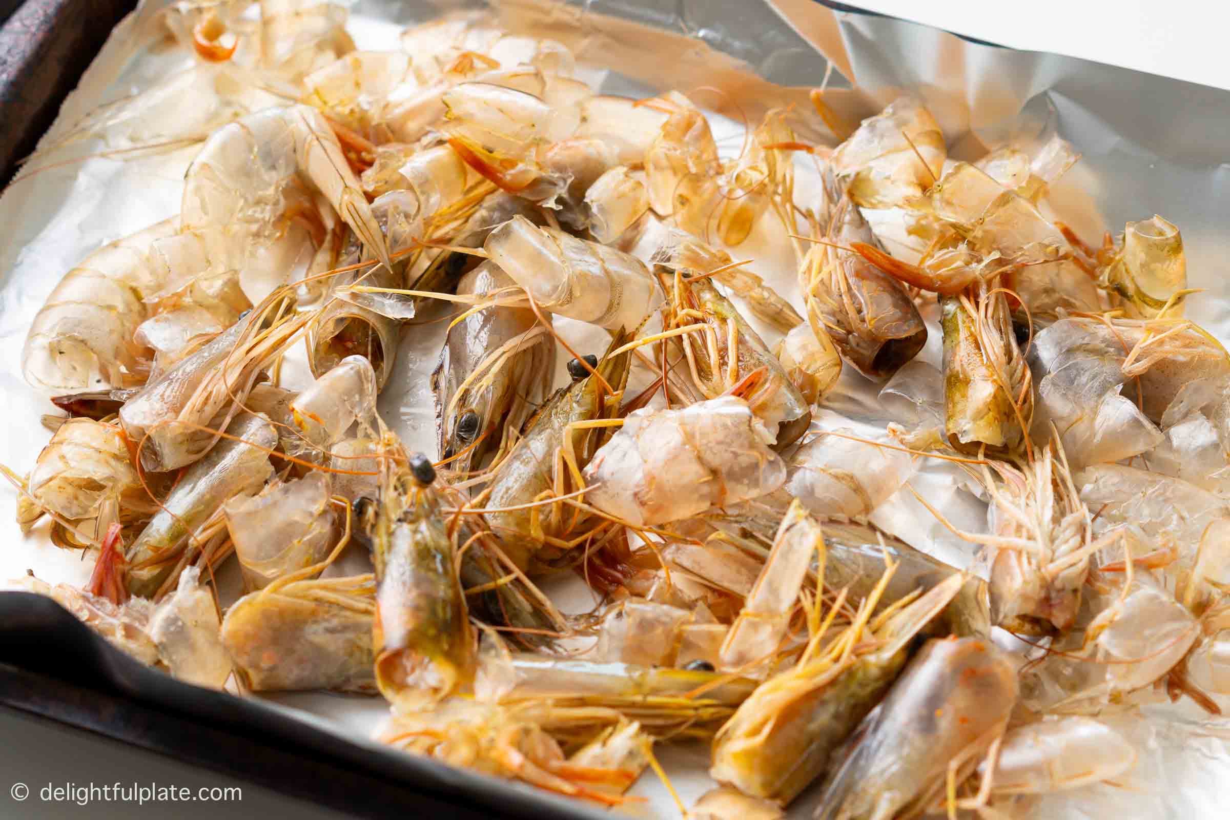 a tray of raw shrimp shells and heads.