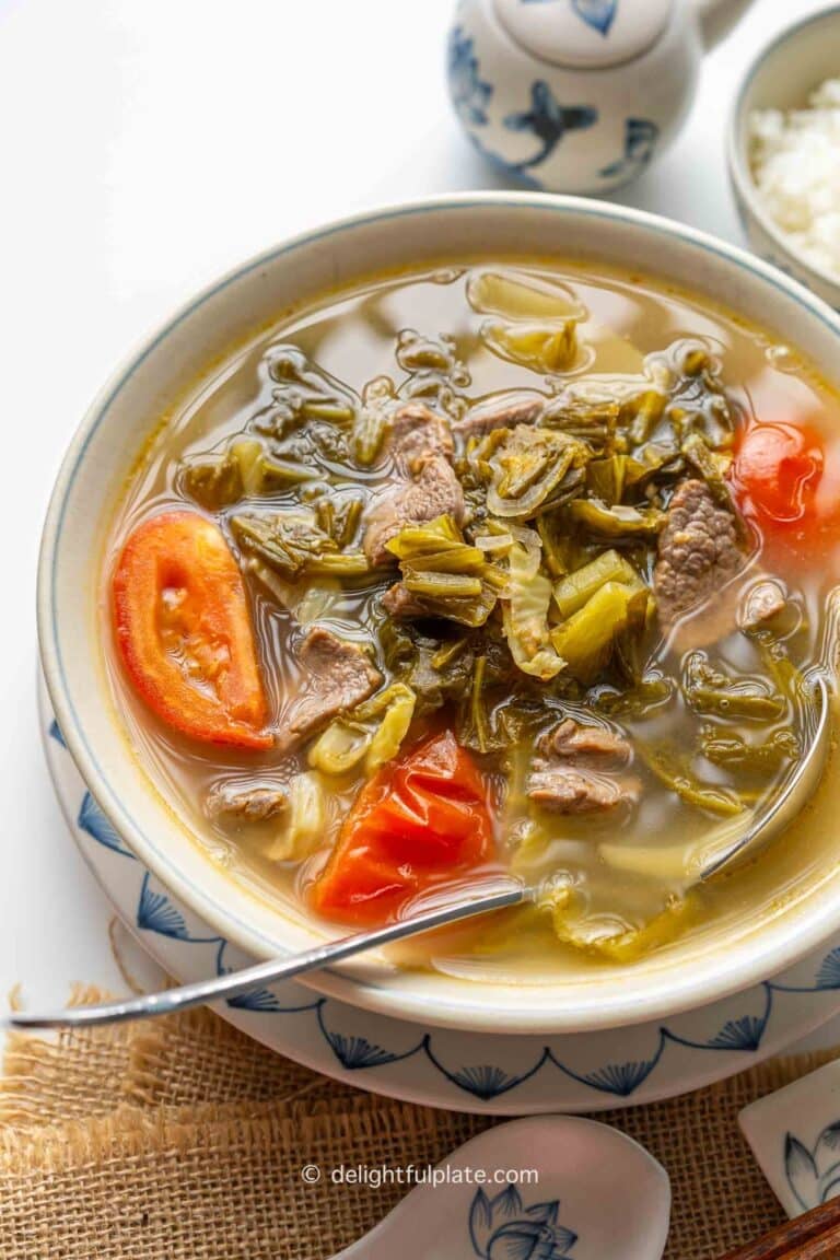 a bowl of Vietnamese beef soup with pickled mustard greens.