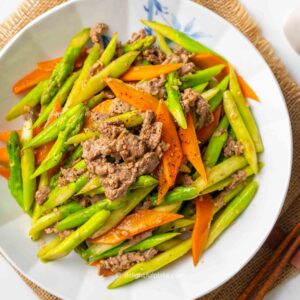 a plate of beef and asparagus stir-fry.