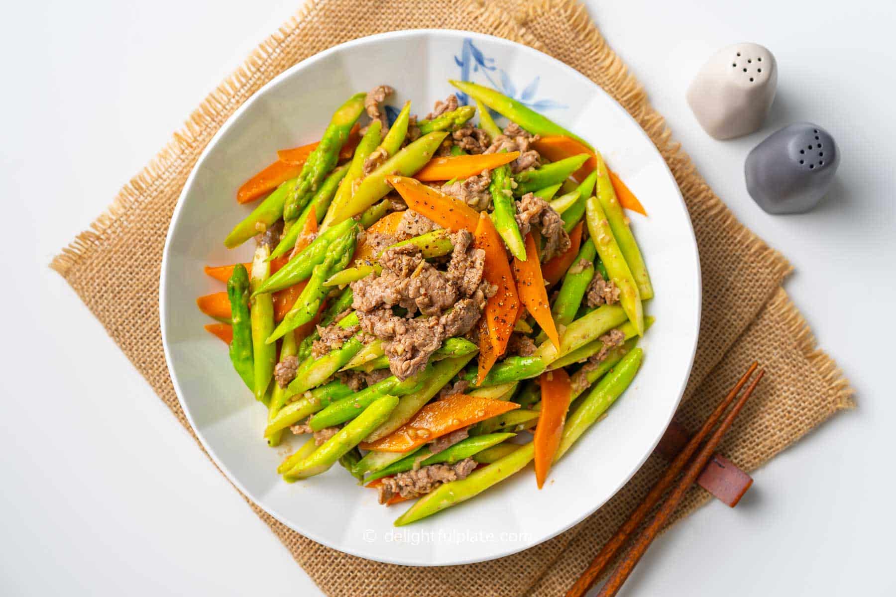 a plate of stir-fried asparagus with beef.