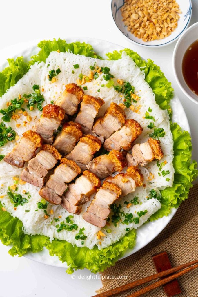 a plate of Heo Quay Bánh Hỏi (Vietnamese Crispy Pork Belly with Fine Rice Vermicelli Sheets).
